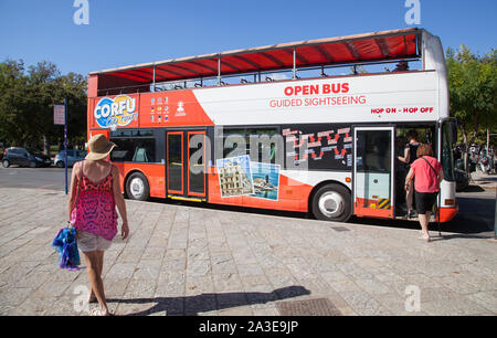 Leute, die ein und aus einem oben offenen sightseeing Hop on Hop off Doppeldeckerbus in der Griechischen Stadt Korfu Griechenland Stockfoto