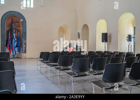 Napflio Griechenland - 18 Juli 2019; Pianist etwas verschwommen in langen Exposition in leeren Stadt Nafplio Halle spielen schöne Musik zu niemand. Stockfoto