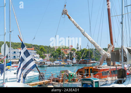 Classic Old Yacht mit lackierten Holz- Kabine und Spieren mit Seilen und bleibt nah Aufund grüne low Hügel im Hintergrund von Ermioni Hafen. Stockfoto