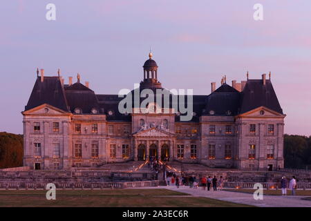 Château de Vaux-le-Vicomte in der Dämmerung mit Kerzen in Windows und Besucher Queuing, Maincy, Seine-et-Marne, Region Île-de-France, Frankreich Stockfoto