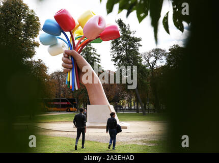 Peking, Frankreich. 7 Okt, 2019. Die Menschen sammeln sich um die Skulptur "Blumenstrauß aus Tulpen" in der Nähe von Petit Palais in Paris, Frankreich, 7. Oktober, 2019. Amerikanische Künstler Jeff Koons vorgestellt in Paris am 4. Oktober seine Skulptur "Blumenstrauß aus Tulpen", eine Hommage an die Opfer der Terroranschläge in der französischen Hauptstadt im November 2015. Die 12 Meter hohe Skulptur zeigt eine riesige Hand zusammendrücken ein Bouquet von elf bunte Tulpen. Credit: Gao Jing/Xinhua/Alamy leben Nachrichten Stockfoto