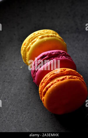 Bunte sweet cookies Hintergrund mit kopieren. Drei macarons oder Makronen auf dem dunklen Steigung grauer Hintergrund gestapelt. Selektive konzentrieren. Stockfoto