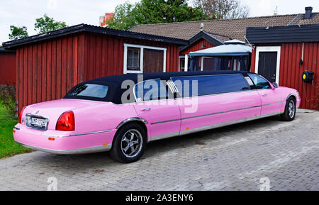 Umea, Schweden - 15. September 2019: Ein Rosa Limo steht in der Einfahrt mit einem roten Haus im Hintergrund Stockfoto