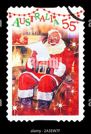 Australien - ca. 2010: Eine gebrauchte Briefmarke aus Australien, eine festliche Szene des Weihnachtsmannes liest einen Brief vor dem Kamin, ca. 2010 darstellt. Stockfoto