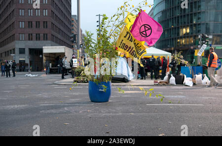 Berlin, Deutschland. 08 Okt, 2019. Eine Anlage mit den Flaggen der Klima Bewegung' Aussterben Rebellion' steht am Scheideweg am Potsdamer Platz. Die Polizei setzte die Evakuierung der Klima Proteste am Potsdamer Platz in Berlin frühen Dienstag Morgen. Da sie den Platz links, die Aktivisten nahmen ihre Sachen und Müll mit Ihnen zurück. Credit: Paul Zinken/dpa/Alamy leben Nachrichten Stockfoto