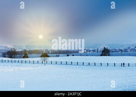 Winterlandschaft früh morgens nach einem leichten sknowfall in Zug in der Schweiz. Mit Spuren im Schnee und Bäume Stockfoto