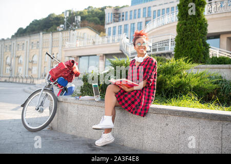 Schüler draußen zu sitzen und die Vorbereitung für die Klassen nach dem Reiten Fahrrad Stockfoto