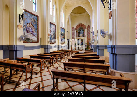 Novelda, Spanien - Oktober 3, 2019: Das innere Heiligtum der Santa Maria Magdalena alte Kloster in Novelda mit Symbolen Auf wände Holz- leere Kirchenbänke Stockfoto