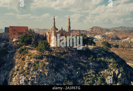 Malerische Antenne drone Sicht Fotografie von Heiligtum der Santa Maria Magdalena erhebt sich auf der Oberseite des Rocky Mountain in Novelda Stadt Stockfoto