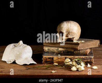 Klassisches Baroque-Stillleben im Vantias-Stil mit Schädel und Death-Maske auf schwarzem Hintergrund Stockfoto