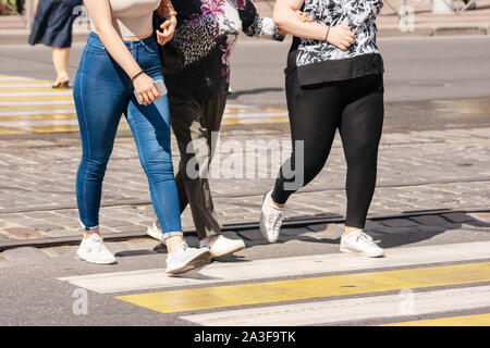 Beine der jungen Fußgänger auf dem Zebrastreifen in der Stadt im Sommer Tag Stockfoto