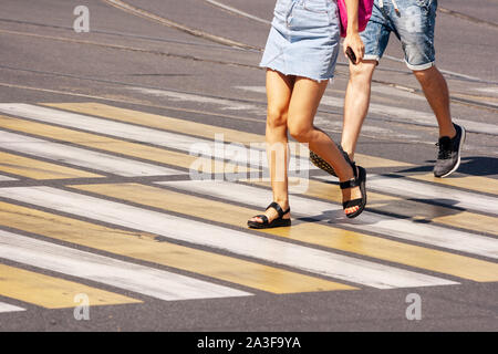 Beine der jungen Fußgänger auf dem Zebrastreifen in der Stadt im Sommer Tag Stockfoto