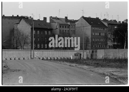 Blick über das Land der Berliner Mauer ist kein Mann, von Osten nach Westen im Bereich der Friedrichstraße, ein kleines, unscharfes Bild aus einem der Fenster eines Gebäudes auf der rechten Seite des Bildes auf der Suche gesehen werden kann. Das Bild zeigt geharkte Erde und Panzersperren in der Ferne in der Nähe der Wand. Stockfoto