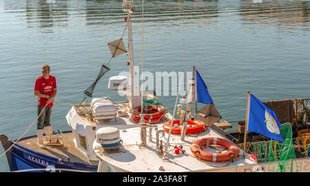 Der Hafen von Scarborough. Ein Fischerboot im Vordergrund mit einem jungen Fischer arbeiten mit einem Seil auf den Bogen. Stockfoto