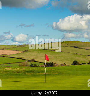 Eine helle rote Flagge auf einem Golfplatz Loch Stockfoto