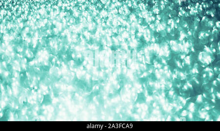 Weihnachten und Neujahr Urlaub Neo Mint Green Glitter schimmernden Festliche abstrakte Textur Hintergrund mit Bokeh defokussierten leuchtet Stockfoto