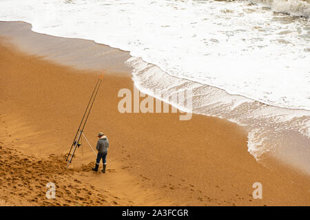 Ein Mann angeln im Meer am Strand Stockfoto