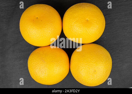 Gruppe von vier ganze frische helle orange flatlay am grauen Stein Stockfoto