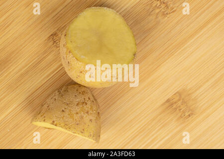 Gruppe von zwei Hälften von Roh braun Kartoffel flatlay auf hellem Holz. Stockfoto