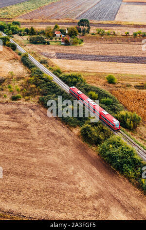 Red Personenzug über Land reisen, Luftaufnahme von Drone pov im Herbst am Nachmittag Stockfoto