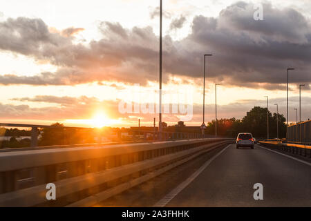 Fahren bei Sonnenuntergang Blick von innen Fahrzeug mit Verkehrsbehinderung voraus Stockfoto