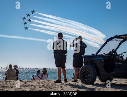 Strand Patrouille Offiziere beobachten, wie die US Air Force Thunderbirds Air Demonstration Squadron swoop über Huntington Beach während einer Straßenüberführung an der Great Pacific Air Show Oktober 6, 2019 in Huntington Beach, Kalifornien. Stockfoto