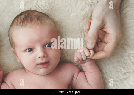 Ein niedliches Baby hält auf Väter Finger. Vaterschaft Konzept Stockfoto