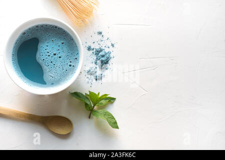 Zeremonie blau Matcha Tee in der Schüssel und Bambus chasen auf weißem Beton. Ansicht von oben. Platz für Text. Stockfoto