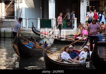 Touristen, die an einem Sommerabend in Venedig in Gondeln fahren Stockfoto