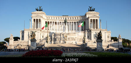 Blick auf die Altare della Patria, bekannt als Il Vittoriano, auf der Piazza Venezia, mit Touristen auf der Straße vor dem Denkmal. Stockfoto