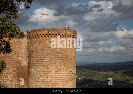 Touristen, die an einem trüben Sommerabend von der Spitze eines Turms in der Fortezza Albornoz in Orvieto ein Bild machen. Stockfoto