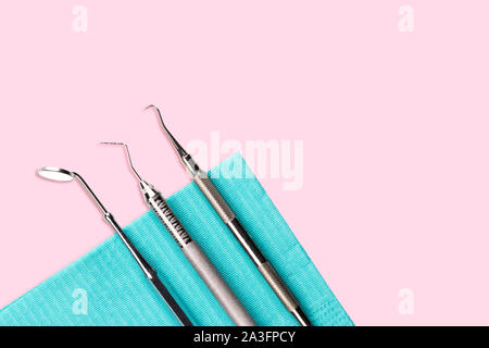 Zahnarzt Werkzeuge über leicht rosa unterlegt zahnmedizinische Hygiene und Gesundheitswesen Konzept. - Bild Stockfoto
