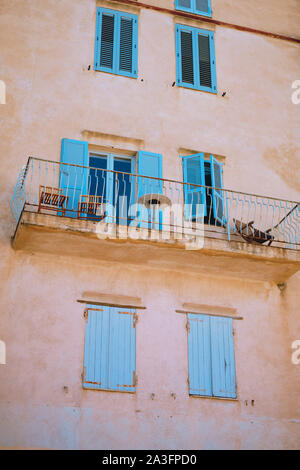 Die bemalten blauen Fensterläden und rosa Fassade balkon Architektur der alten Stadt und die Zitadelle von Bonifacio auf Korsika in Frankreich. Stockfoto
