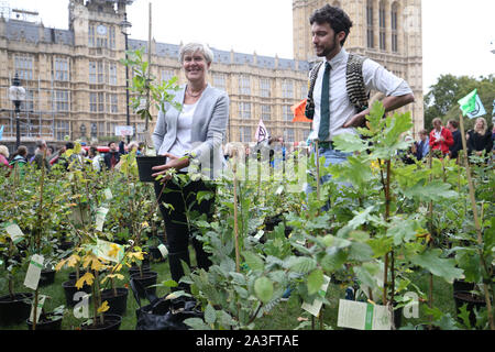 Labour MP, Kate Grün (links) unter den Setzlinge im Alten Schloss Hof außerhalb des Parlaments, durch Demonstranten, während ein Aussterben Rebellion (XR) Protest in Westminster, London. Stockfoto