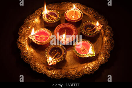 Happy Diwali. Ton diya Kerzen in Dipavali beleuchtet, Hindu Festival der Lichter. Traditionelle Öllampen auf dunklem Hintergrund Stockfoto