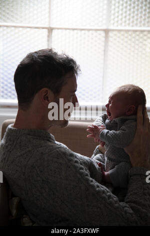 Vater trösten ein schreiendes Baby umgekippt. Vaterschaft, Erziehung Konzept Stockfoto