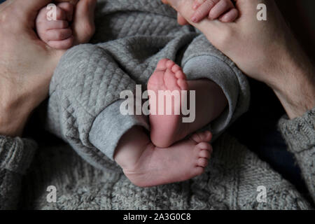 Nahaufnahme von einem Vater Holding neu geborenen Babys Hände Stockfoto