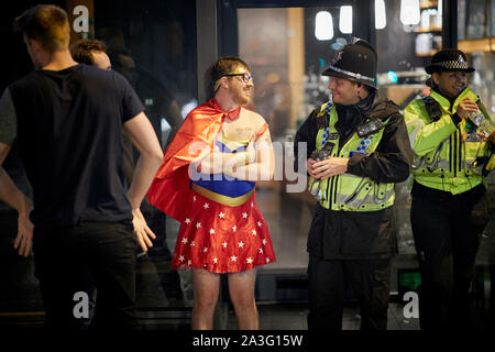 Cardiff Wales, Mann in Fancy Dress wie Wonderwoman gekleidet zur Polizei chatten Stockfoto