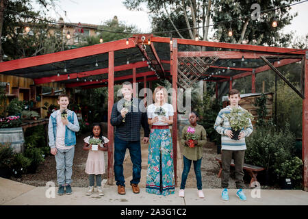 Multirassischen Familie Pflanzen im Kindergarten in Kalifornien Holding Stockfoto