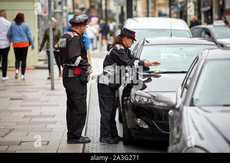 Cardiff Wales, an der High Street Rat öffentlichen Diener Politessen, die ein Ticket Stockfoto