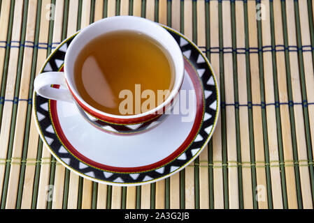 Eine Tasse erfrischend grünen auf einer hölzernen Matte. Stockfoto