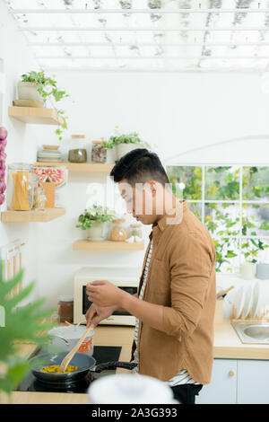 Junge asiatischer Mann Vorbereitung Mahlzeit in der Küche Stockfoto