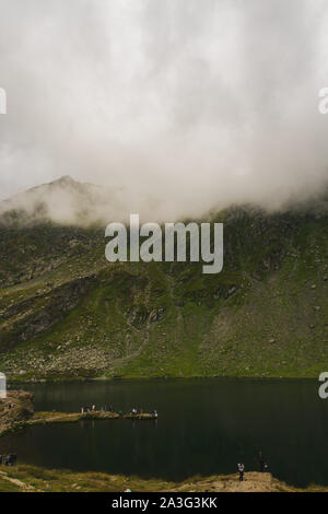 Schöne Aussicht von Fagaras Berge in Nebel und Touristen, die Balea Gletschersee im Sommer abgedeckt, Rumänien Stockfoto