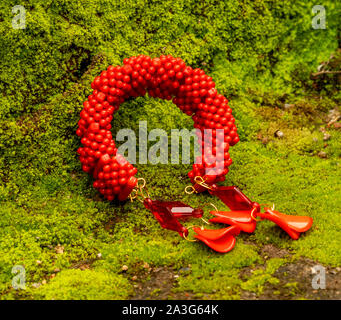 Dekorative rot mit Perlen auf moss Hintergrund Stockfoto