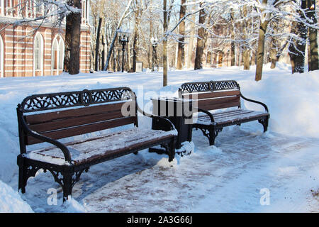 Leere Bänke in der Mitte eines schneebedeckten City Park. Schöne Bäume in Weiß Schnee bedeckt. Winter Park. Schnee bedeckt der Wald. Eine Menge flauschige Schnee. Ba Stockfoto