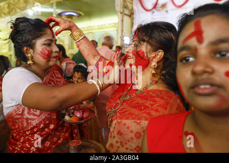 Dhaka, Bangladesch. 8. Oktober, 2019. Hindu devotees Vermillion auf jedem anderen Abstrich bei Sindoor Khela am letzten Tag der Durga Puja in Dhaka, Bangladesch, 8. Oktober 2019. Durga Puja oder Sharadotsav ist eine jährliche Hindu Festival in Südasien, feiert den Gottesdienst der hinduistischen Göttin Durga. Die jährliche 5-tägige hinduistische Fest zu Ehren der Göttin Durga, die Kraft und den Sieg des Guten über das Böse in der hinduistischen Mythologie symbolisiert. Credit: Suvra Kanti Das/ZUMA Draht/Alamy leben Nachrichten Stockfoto