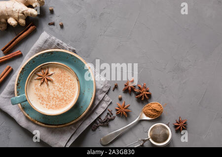 Masala Indischen Tee in Tasse mit Gewürzen auf grauem Beton Tabelle. Ansicht von oben. Platz für Text. Stockfoto