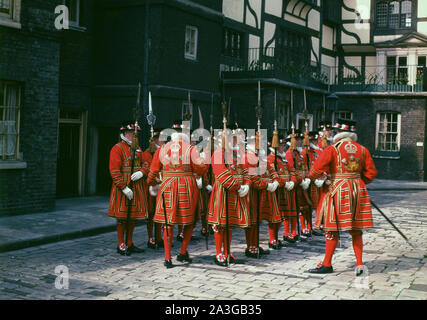 1960er Jahre, historisches Bild von Yeomen Warders in Tudor State Dress. Die Wärter sind zeremonielle Wächter der Festung des Tower of London, eine Pflicht, die bis in die Tudor-Zeit zurückreicht. Alle Wärter sind aus den Armed Forces of Commonwealth Realms ausgeschieden. Stockfoto