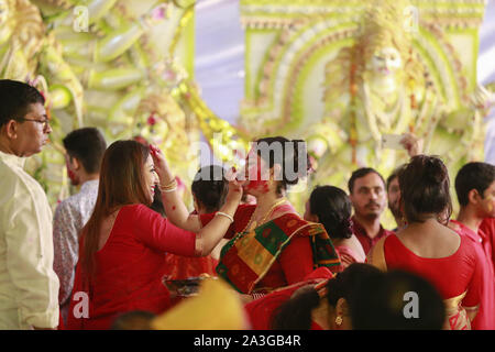 Dhaka, Bangladesch. 8. Oktober, 2019. Hindu devotees Vermillion auf jedem anderen Abstrich bei Sindoor Khela am letzten Tag der Durga Puja in Dhaka, Bangladesch, 8. Oktober 2019. Durga Puja oder Sharadotsav ist eine jährliche Hindu Festival in Südasien, feiert den Gottesdienst der hinduistischen Göttin Durga. Die jährliche 5-tägige hinduistische Fest zu Ehren der Göttin Durga, die Kraft und den Sieg des Guten über das Böse in der hinduistischen Mythologie symbolisiert. Credit: Suvra Kanti Das/ZUMA Draht/Alamy leben Nachrichten Stockfoto