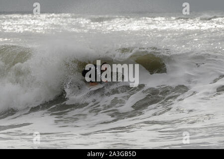 Das Verstauen in der Röhre für die auf einem fässerfüllen Wave surfer Patrick Langdon dunkel Ausbildung in Wales Stockfoto